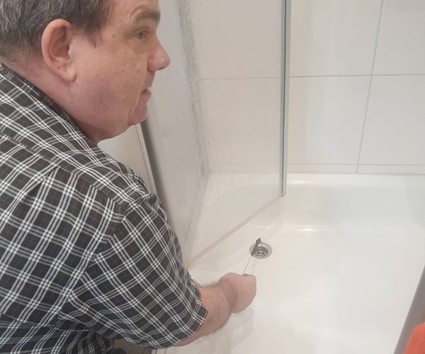 Dusche verstopft Entfernung von Haaren mit einer Strohhalmbürste